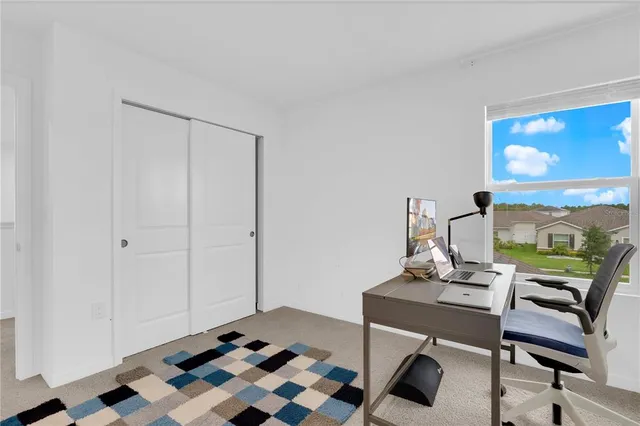 a view of a workspace with furniture and a window