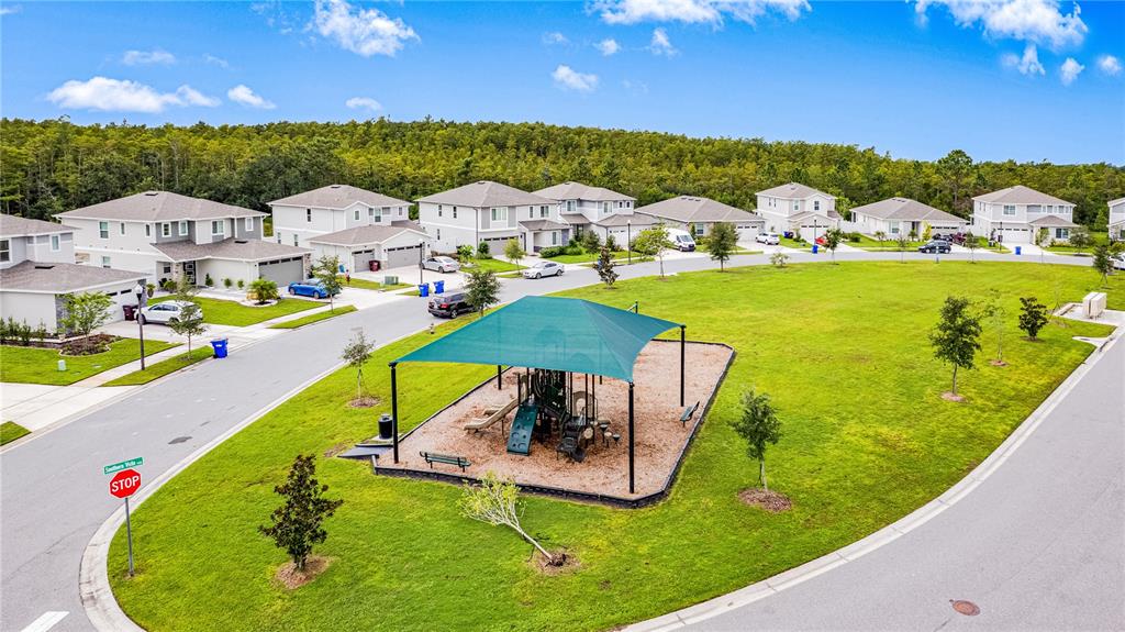 4226 Southern Vista Loop St. Cloud, FL 34772 - Photo 36 of 39 a view of a swimming pool with lawn chairs under an umbrella