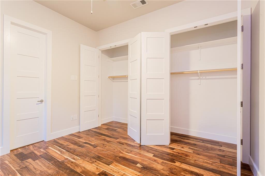 2509 Del Curto Road, Unit B Austin, TX 78704 - Photo 13 of 31 Unfurnished bedroom featuring baseboards, a closet, visible vents, and wood finished floors