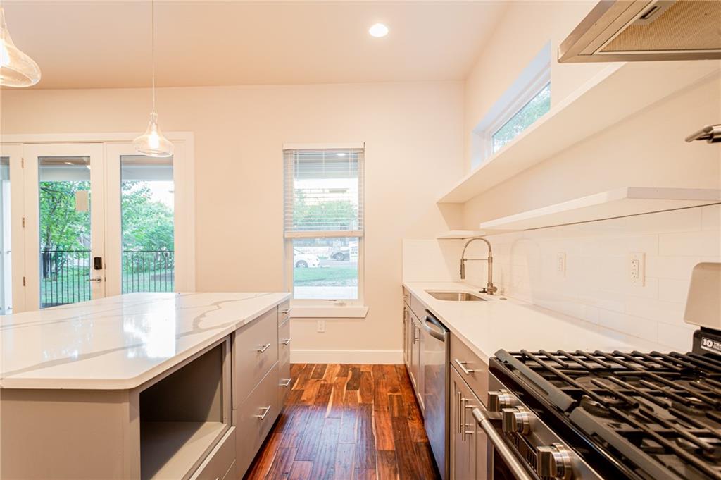 2509 Del Curto Road, Unit B Austin, TX 78704 - Photo 9 of 31 Kitchen featuring a sink, dark wood-style floors, a healthy amount of sunlight, and appliances with stainless steel finishes