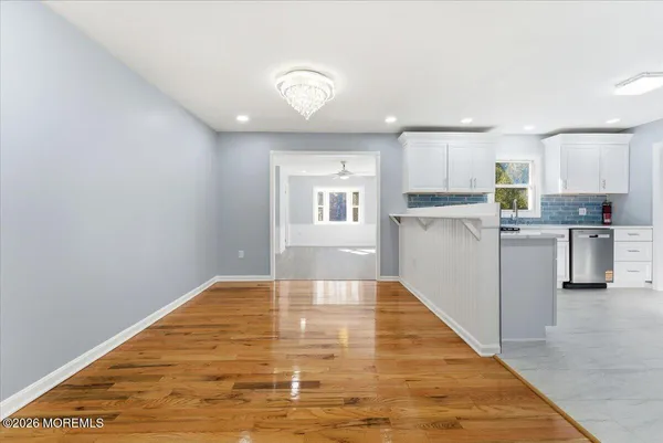 a view of a kitchen with a sink refrigerator and wooden floor