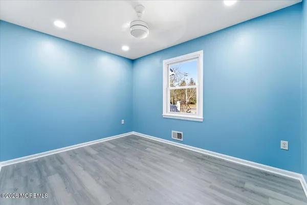 an empty room with a window and a ceiling fan
