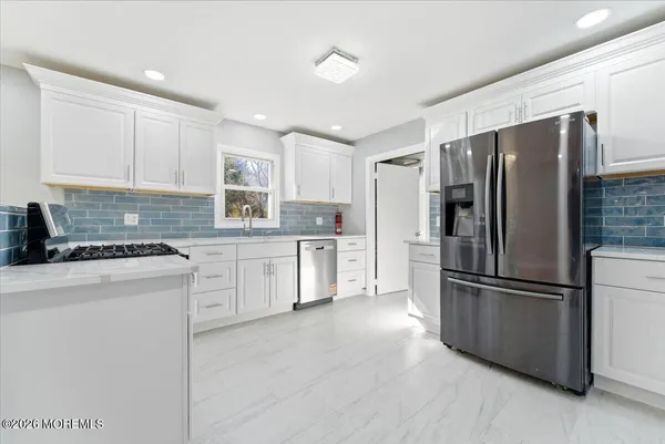 a kitchen with white cabinets and a stove