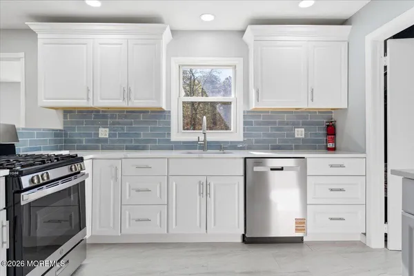 a kitchen with stainless steel appliances granite countertop a sink a stove and a refrigerator