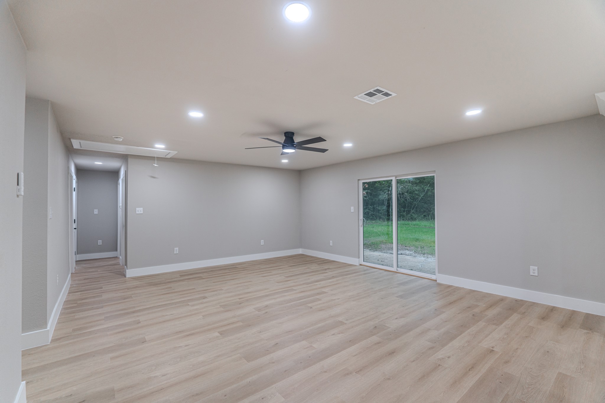 26701 Knottywood Oakhurst, TX 77359 - Photo 14 of 47 an empty room with wooden floor and a ceiling fan