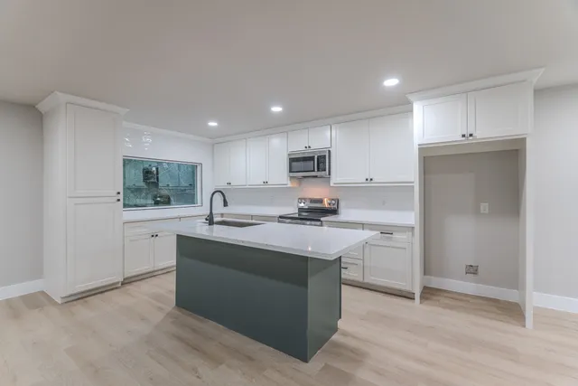 a kitchen with stainless steel appliances granite countertop a sink stove and refrigerator