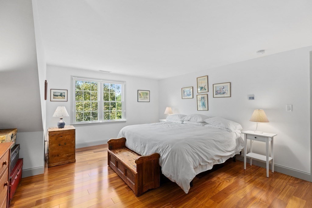 82 Thistle Patch Way, Unit 82 Hingham, MA 02043 - Photo 30 of 39 a bedroom with a bed wooden floor and a lamp on table