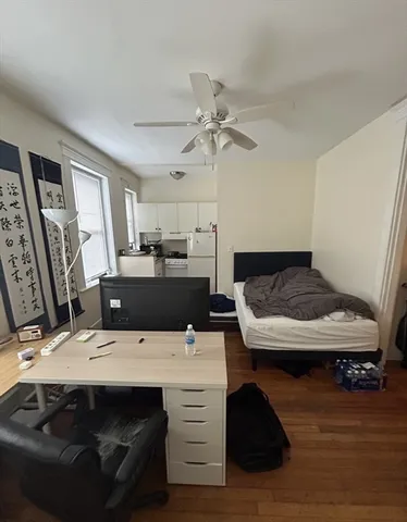 a living room with stainless steel appliances furniture a rug and a view of kitchen