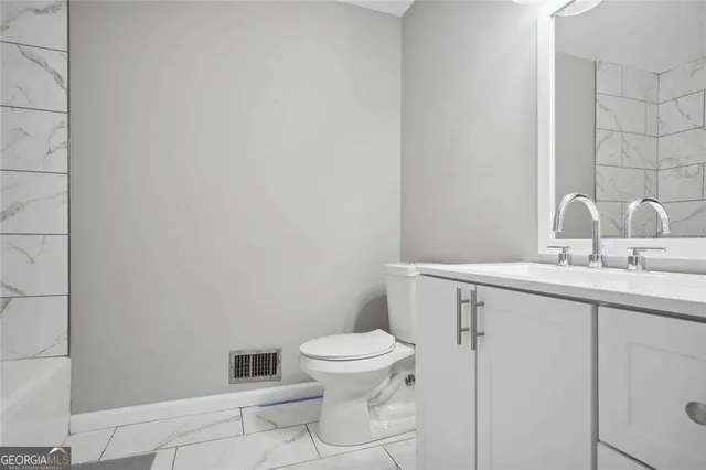 a bathroom with a toilet a sink and mirror