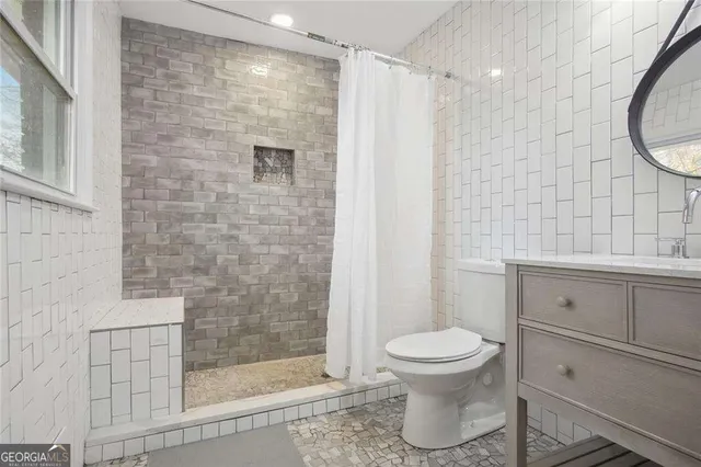 a bathroom with a toilet and a shower