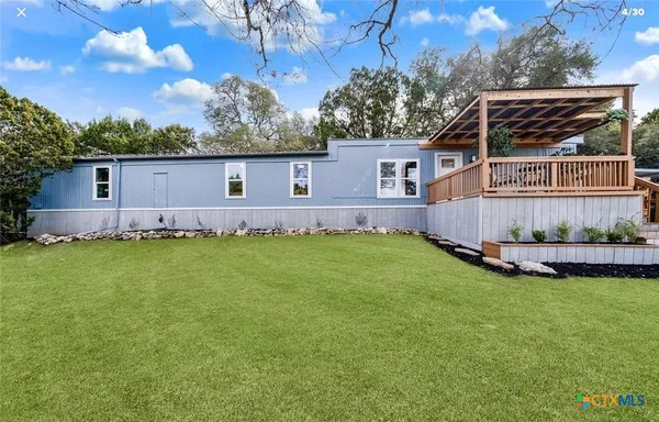 a view of a house with a yard and sitting area