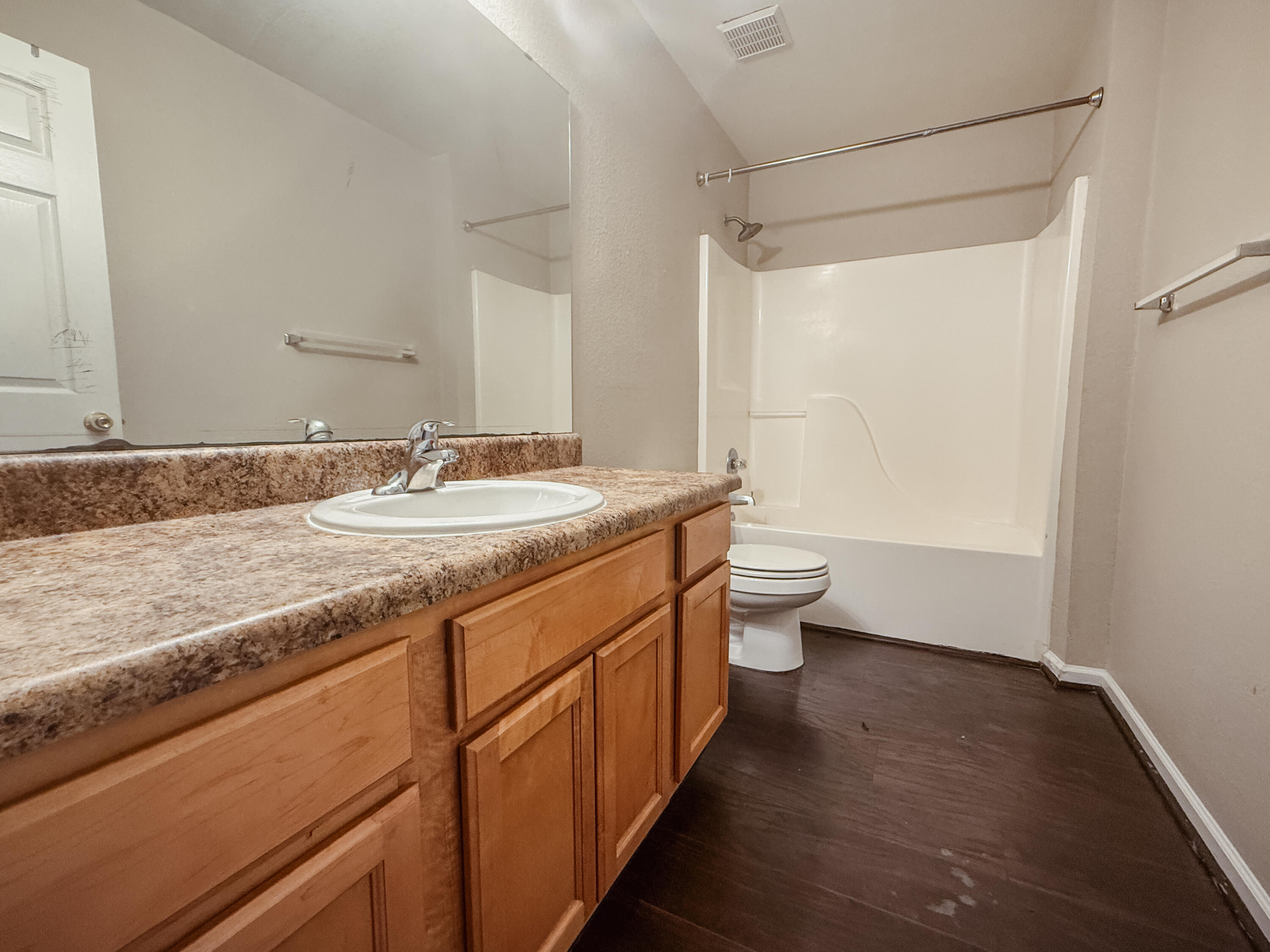 1150 Airport Road, Unit 110 Destin, FL 32541 - Photo 13 of 20 a bathroom with a granite countertop sink a toilet a mirror and shower
