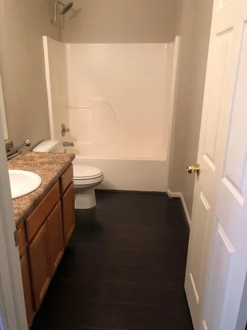 a bathroom with a granite countertop sink toilet and shower