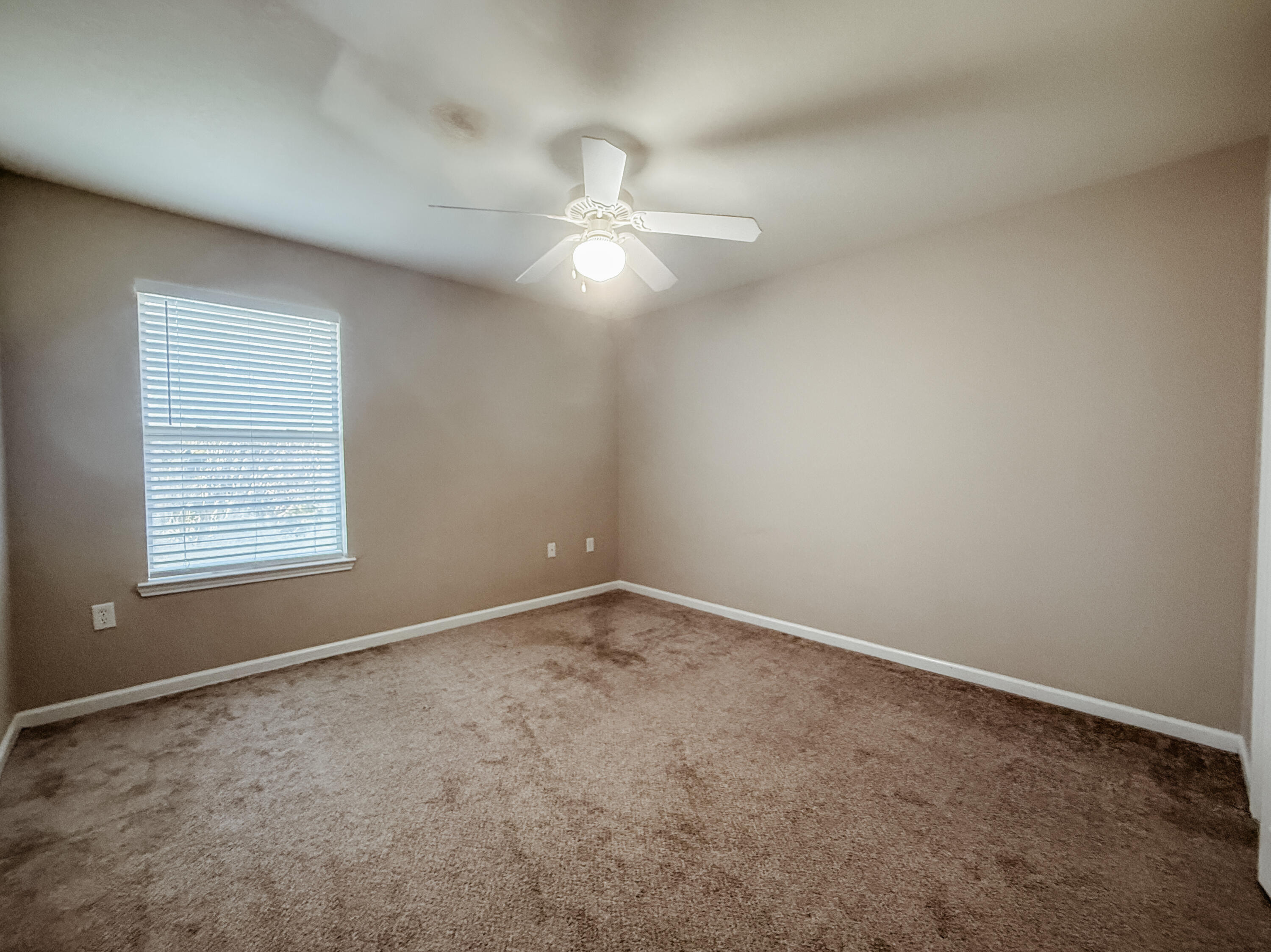 1150 Airport Road, Unit 110 Destin, FL 32541 - Photo 17 of 20 an empty room with a window and ceiling fan