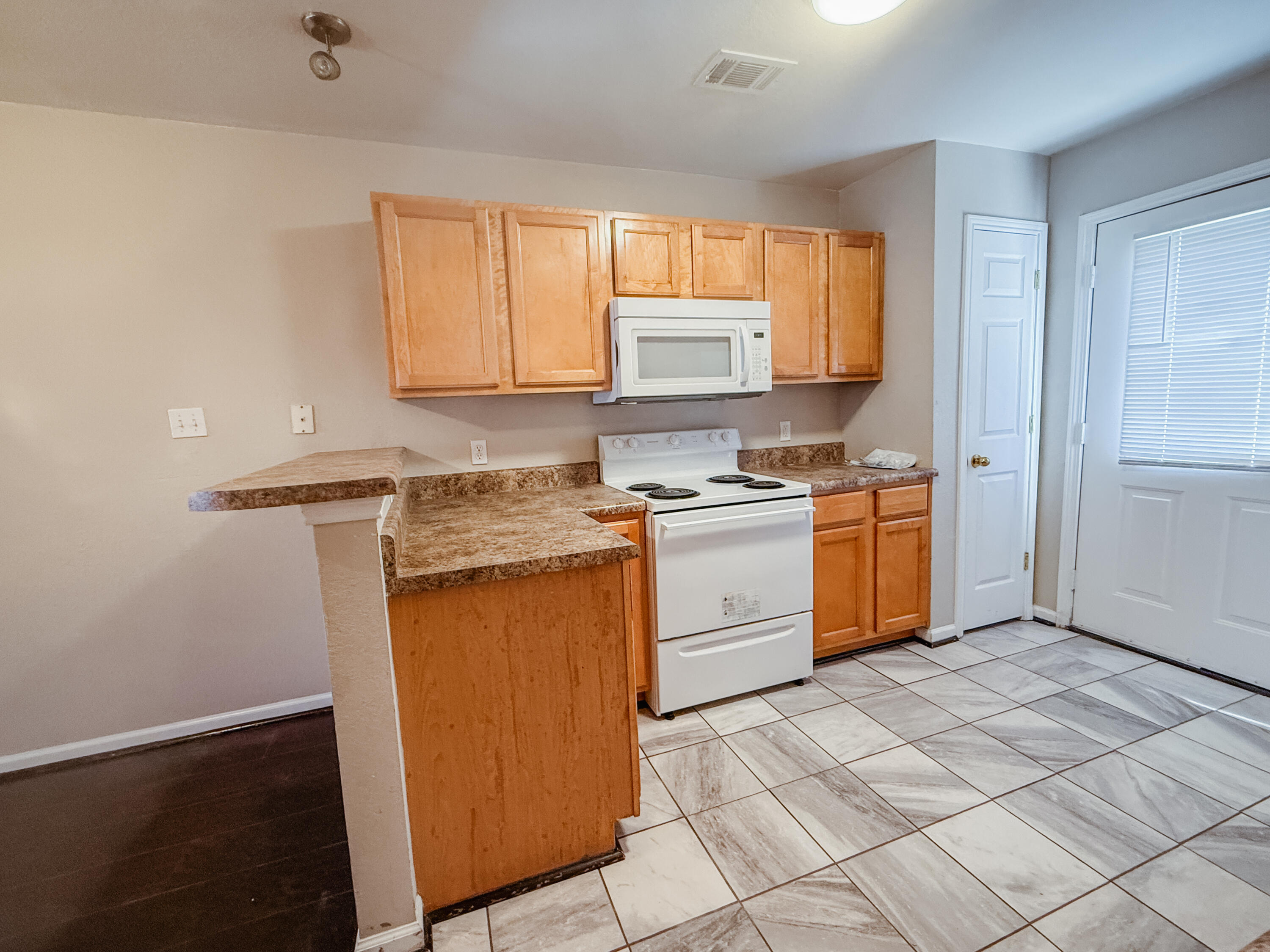 1150 Airport Road, Unit 110 Destin, FL 32541 - Photo 5 of 20 a kitchen with stainless steel appliances granite countertop a stove a sink dishwasher and a refrigerator