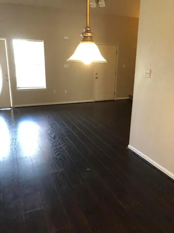 a view of a livingroom with wooden floor and a window