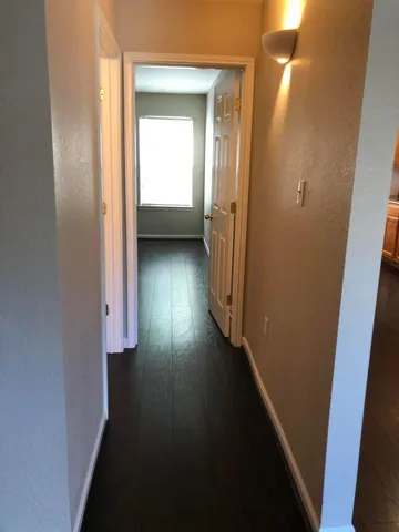 a view of a hallway with wooden floor