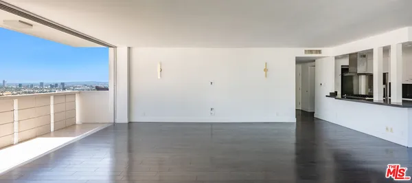 wooden floor in an empty room with a kitchen