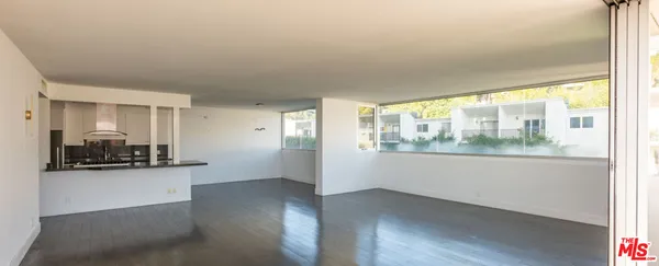 a view of a room with wooden floor and a window