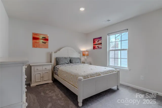 a bed sitting in a bedroom next to a window