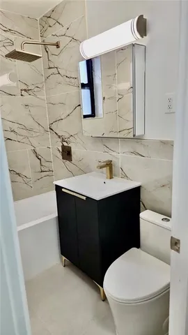 a bathroom with a sink vanity mirror and toilet