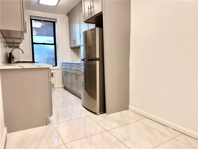a kitchen with stainless steel appliances granite countertop a refrigerator and a sink