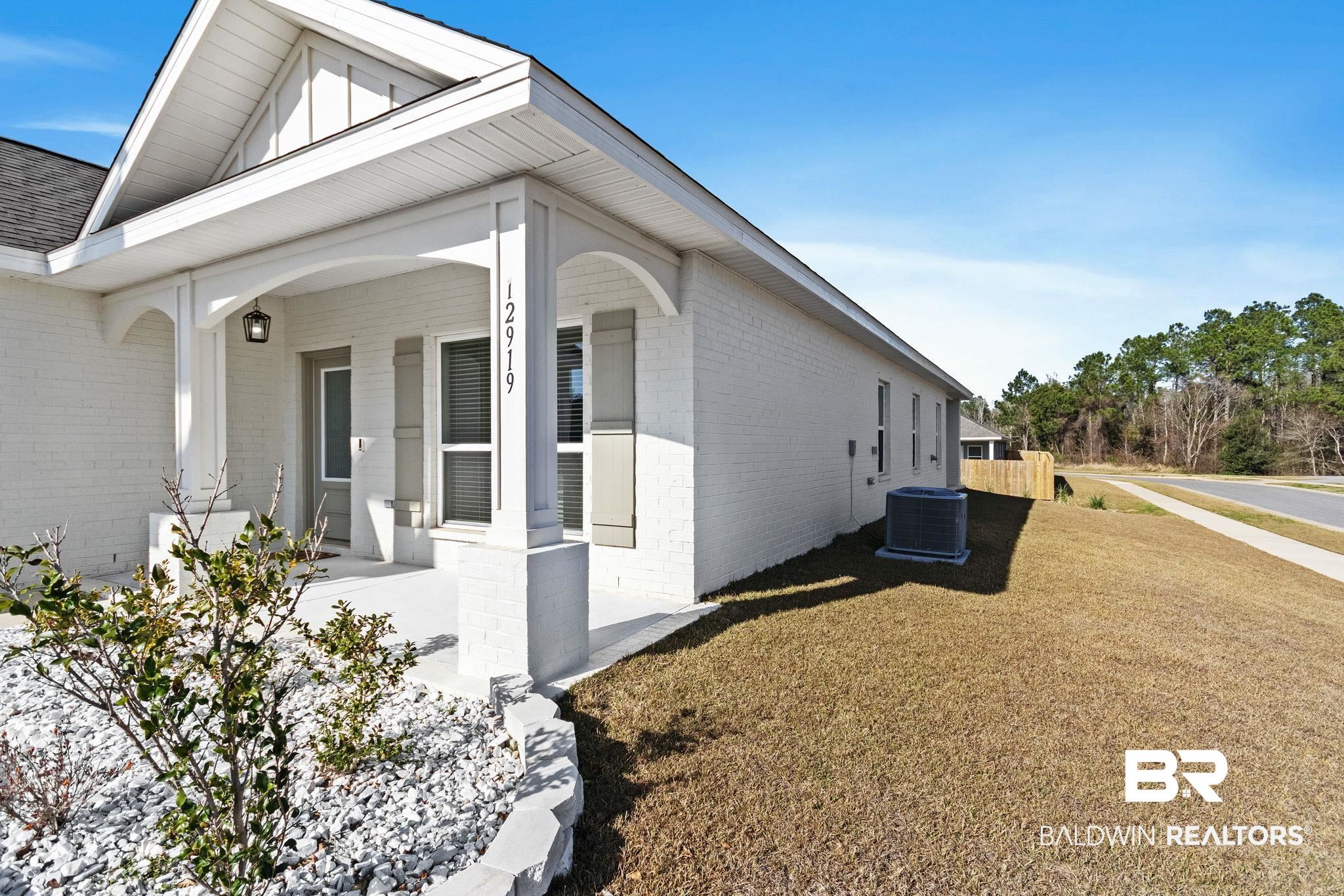 12919 Torrent Road Fairhope, AL 36532 - Photo 10 of 74 View of home's exterior featuring a porch, brick siding, and a yard