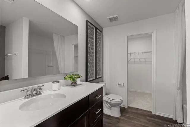 a bathroom with a granite countertop sink toilet a large mirror and shower