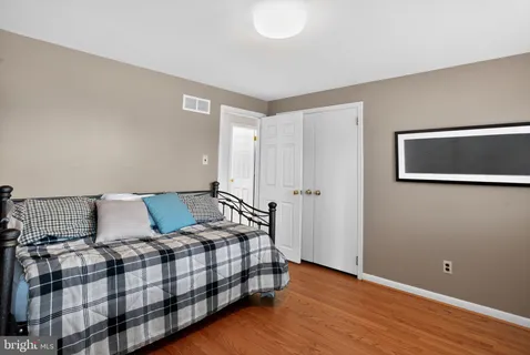 a bedroom with a bed and wooden floor