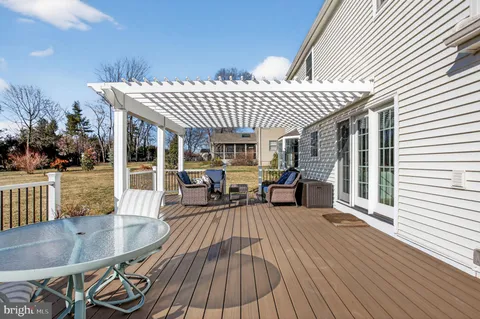 a view of a patio with table and chairs potted plants with wooden floor and fence