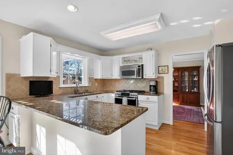 a kitchen with stainless steel appliances granite countertop a sink stove and microwave