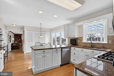 a kitchen with stainless steel appliances granite countertop a sink stove and wooden cabinets