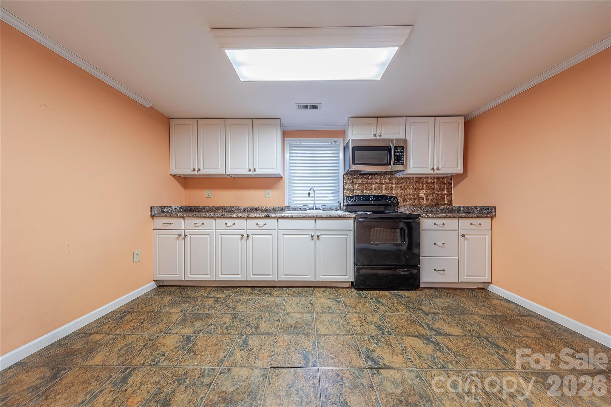 107 Valley Avenue Clover, SC 29710 - Photo 3 of 17 a large kitchen with granite countertop a stove top oven a sink dishwasher and a refrigerator with wooden floor