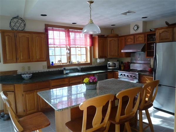 6 Stanley Road Middleton, MA 01949 - Photo 7 of 24 a kitchen with granite countertop a stove a sink dishwasher a dining table and chairs with wooden floor