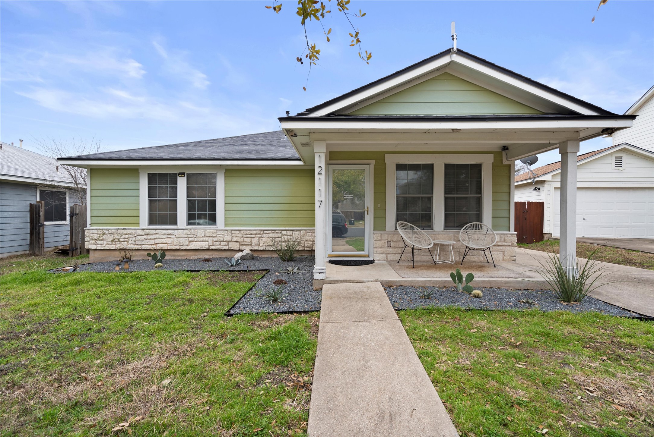 12117 Briarcreek Loop Manor, TX 78653 - Photo 1 of 29 View of front facade featuring a porch, stone siding, roof with shingles, an outbuilding, and a garage