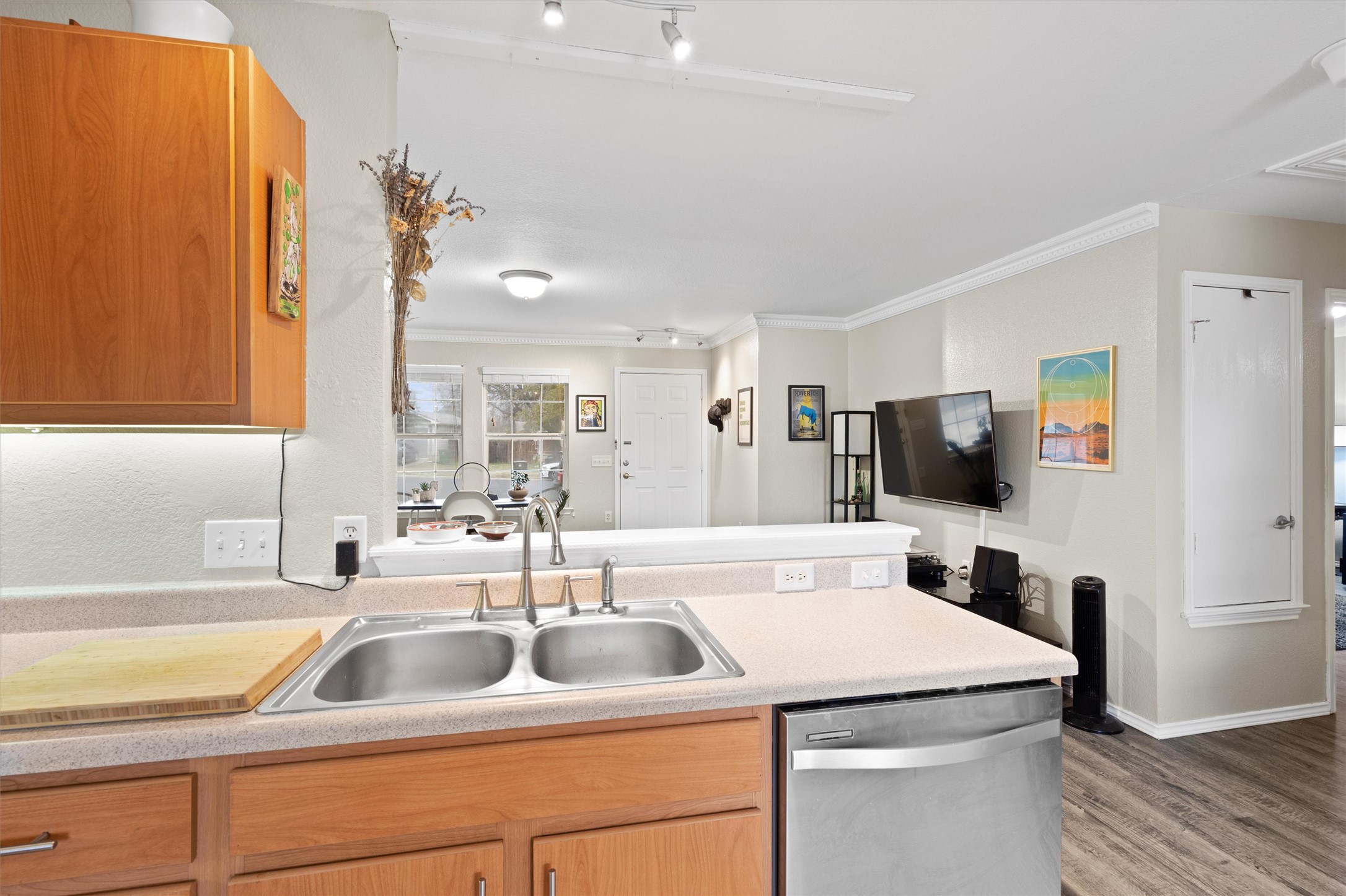 12117 Briarcreek Loop Manor, TX 78653 - Photo 29 of 29 Kitchen featuring a peninsula, stainless steel dishwasher, light countertops, crown molding, and open floor plan