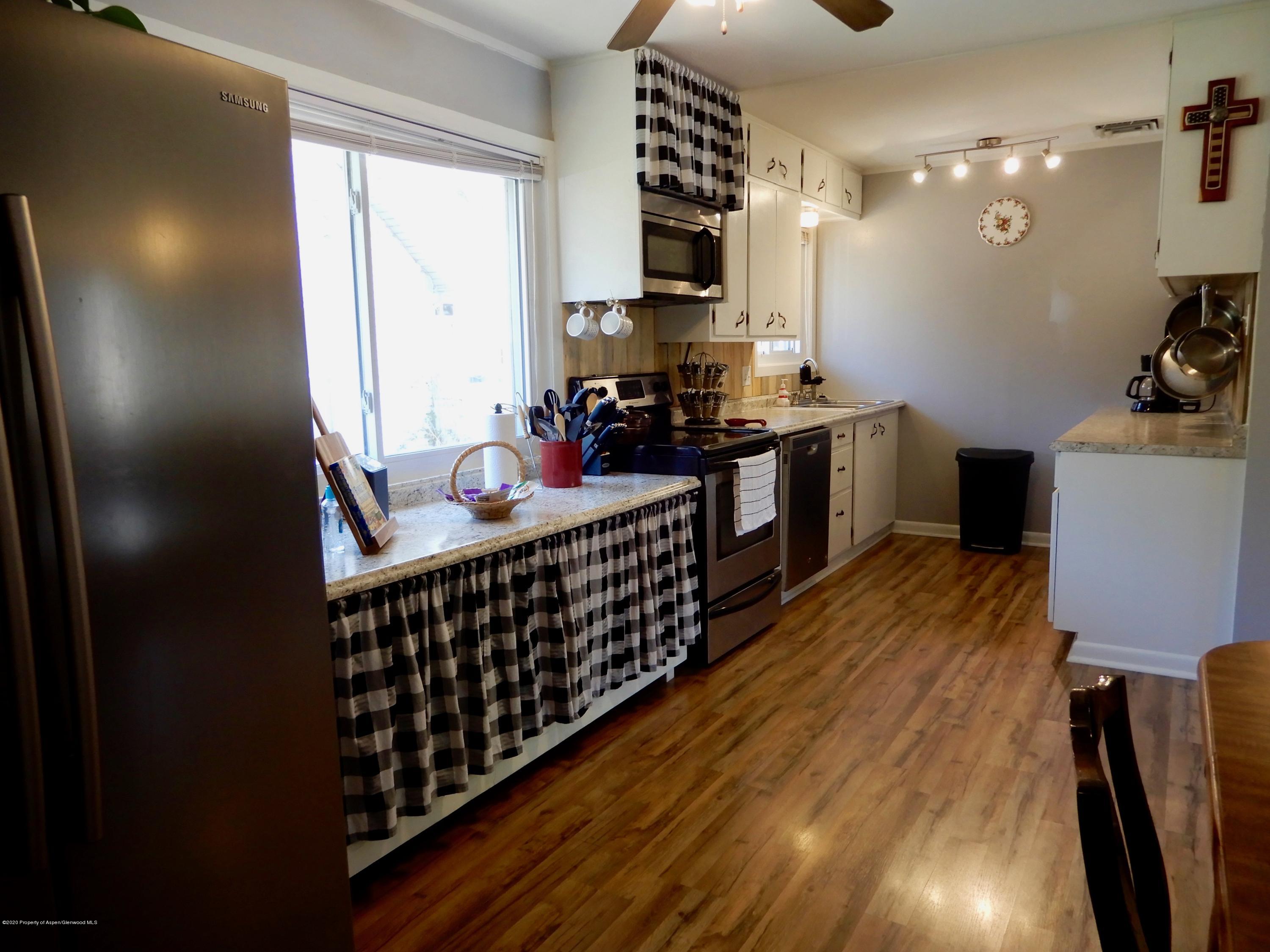 433 East Avenue Rifle, CO 81650 - Photo 10 of 39 a kitchen with stainless steel appliances a sink wooden floor and cabinets