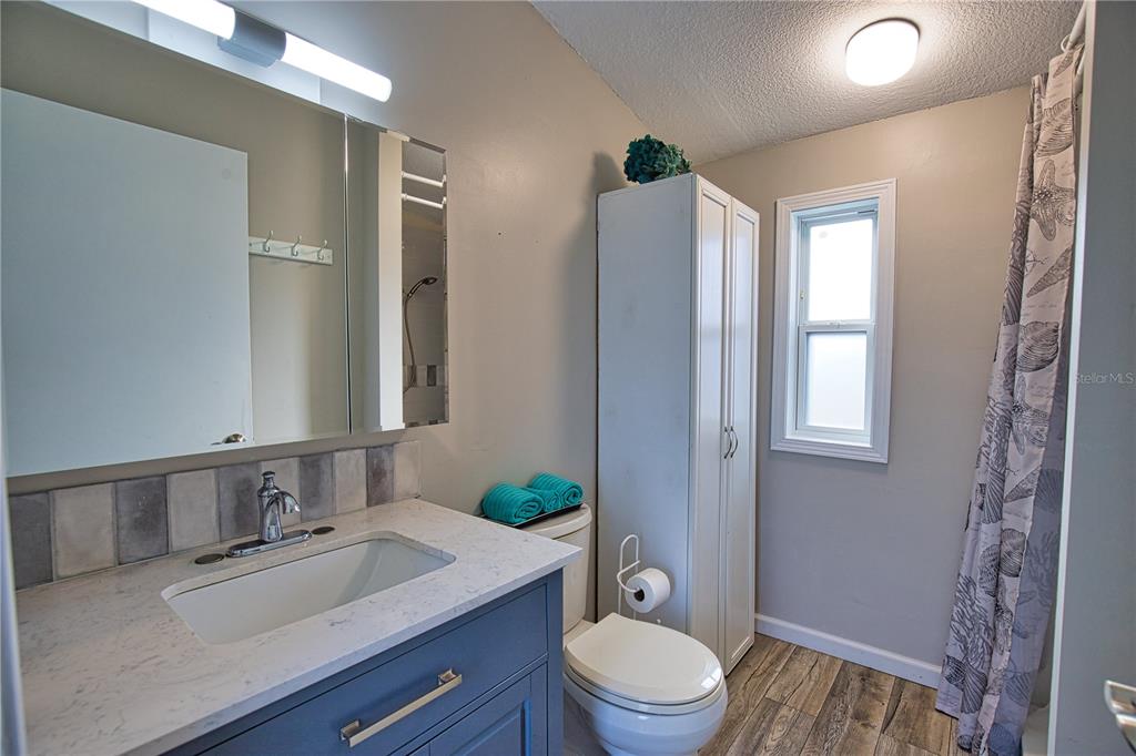 2302 Southeast Red Baron Drive Arcadia, FL 34266 - Photo 18 of 47 a bathroom with a granite countertop sink toilet a mirror and shower