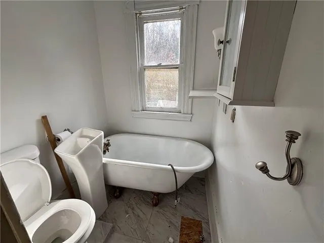 a bathroom with a sink mirror bathtub and window