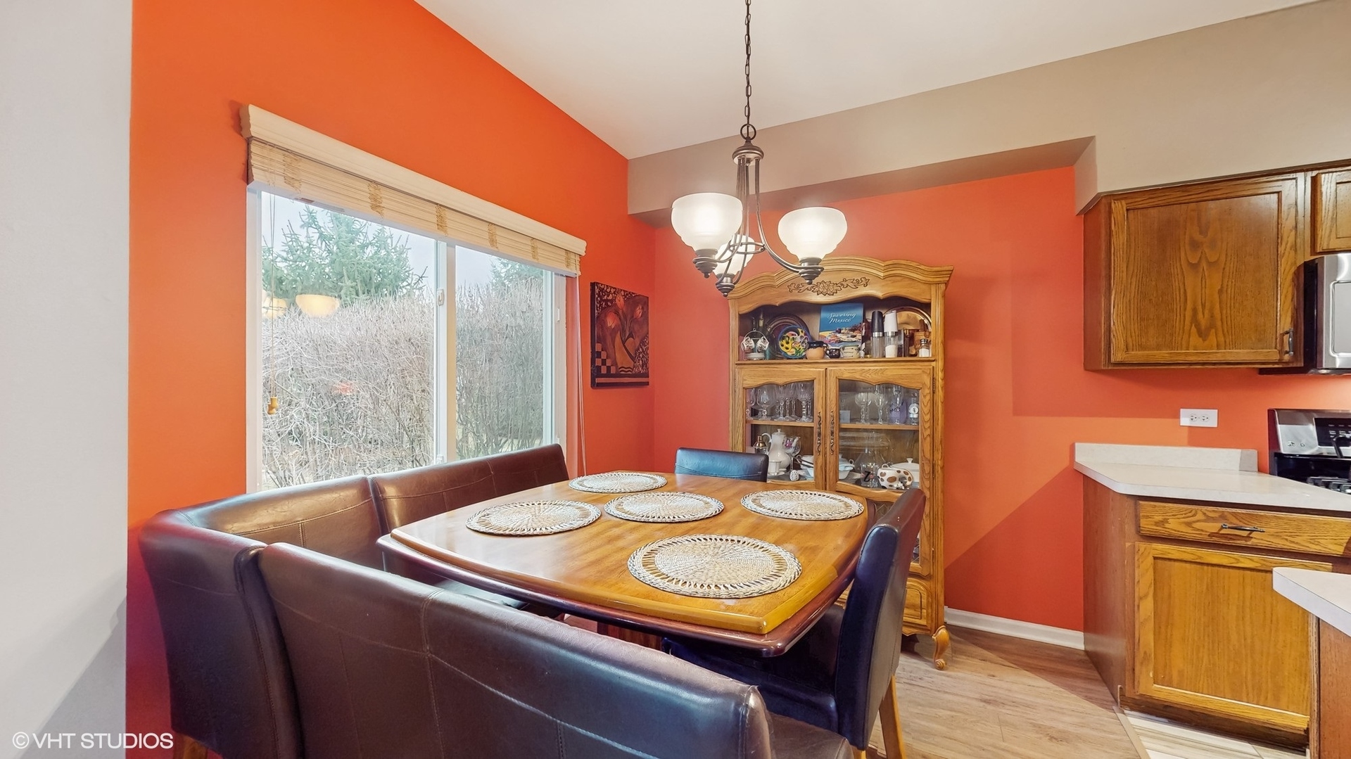 1501 Spaulding Road Bartlett, IL 60103 - Photo 10 of 28 a dining room with wooden floor a chandelier a wooden table and chairs