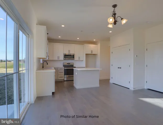 a view of kitchen with stainless steel appliances refrigerator oven and cabinets