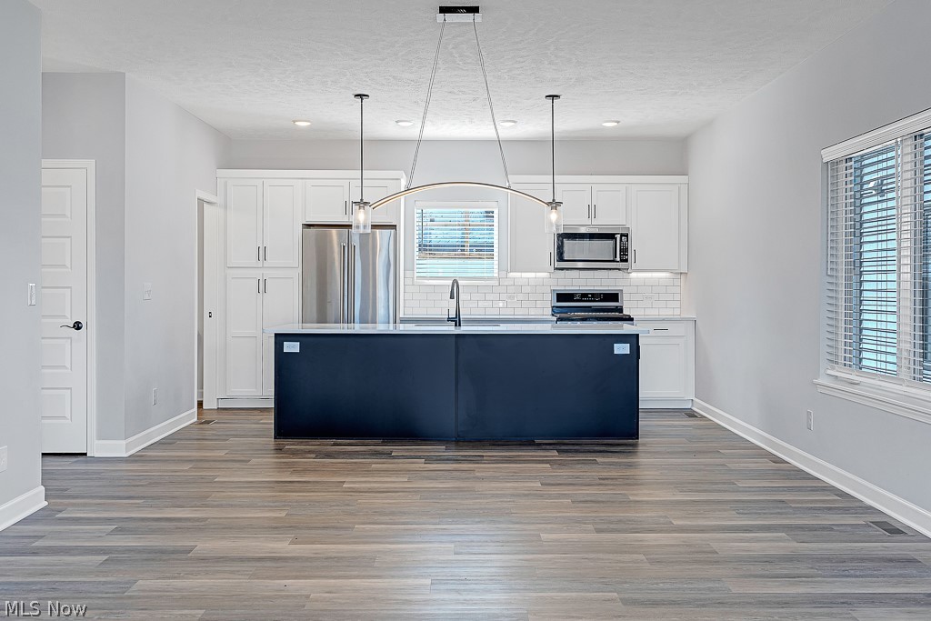 3601 Bailey Avenue Cleveland, OH 44113 - Photo 9 of 22 Kitchen featuring appliances with stainless steel finishes, an island with sink, plenty of natural light, and white cabinetry