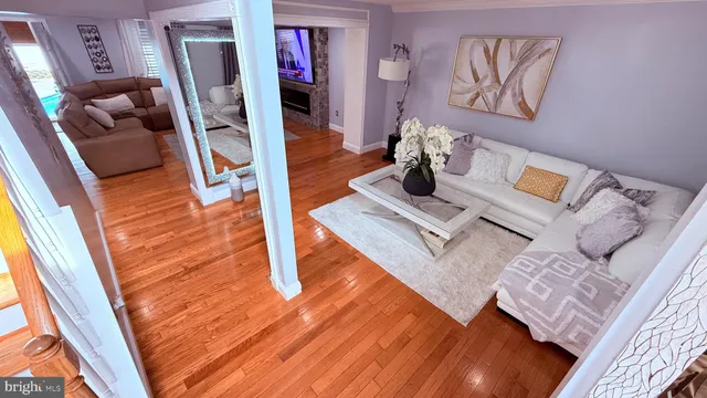 a living room with furniture flowerpot and wooden floor