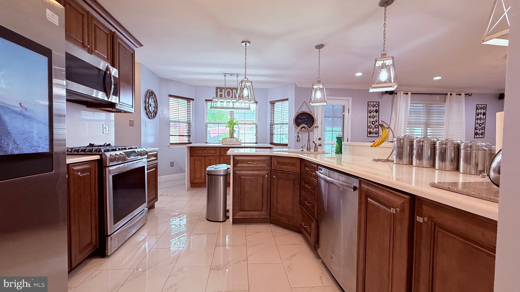 8905 Springview Road Philadelphia, PA 19115 - Photo 32 of 113 a kitchen with stainless steel appliances granite countertop a sink a stove and a wooden floors