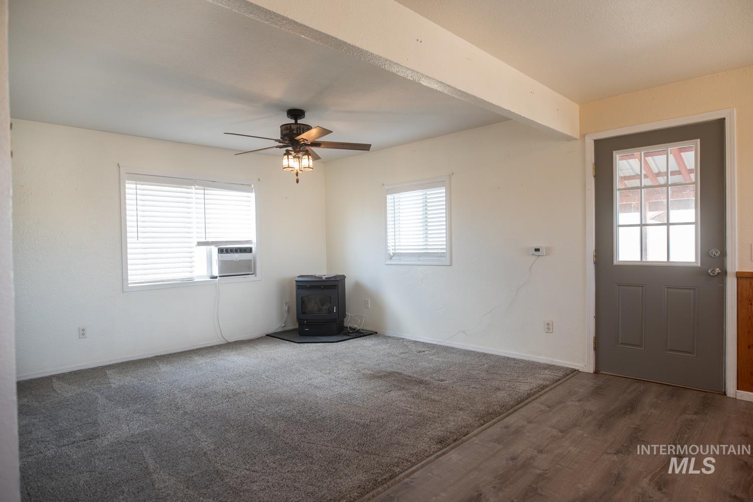 2240 Waite Road Midvale, ID 83645 - Photo 4 of 42 Entrance foyer featuring a wood stove, ceiling fan, wood finished floors, and cooling unit