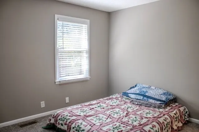 a bedroom with a bed and window