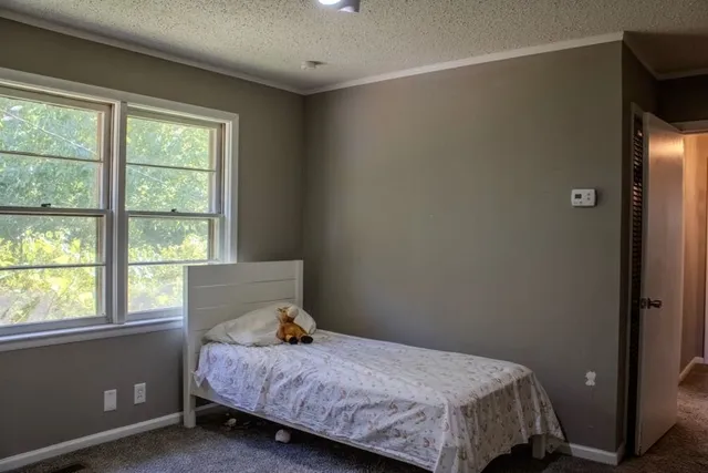 a bed sitting in a bedroom next to a window