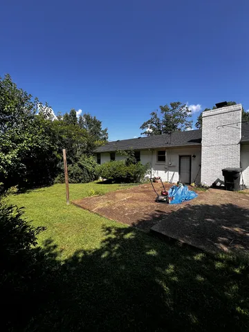 a view of a house with backyard and sitting area