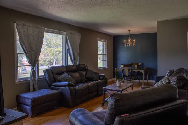 a living room with furniture a window and a flat screen tv