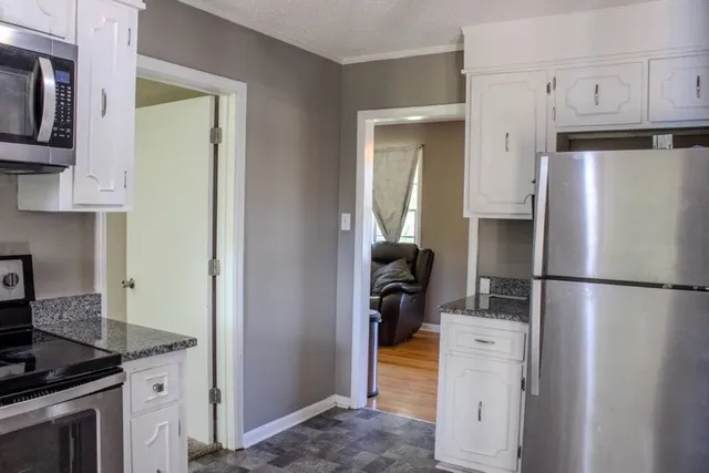 a kitchen with a refrigerator sink stove and cabinets